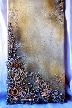 an old book with gears and wheels on the cover is sitting on a white sheet