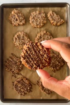 a person holding up a cookie in front of some cookies