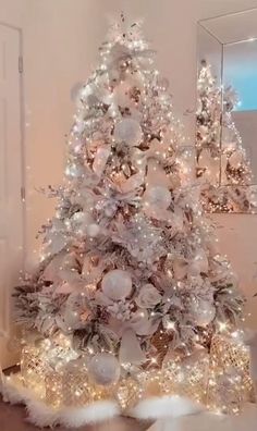 a white christmas tree with lights and ornaments