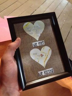 someone is holding up a framed photo with two hearts on it