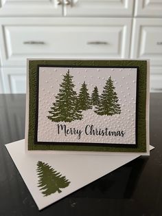 a christmas card with pine trees on it