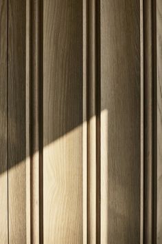 a wooden door with the light coming through it's slatted design on top