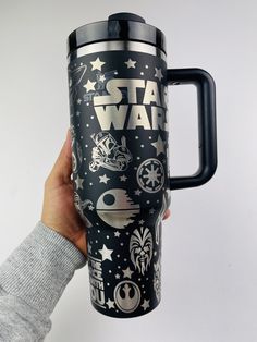 someone holding up a star wars travel mug