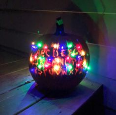 a lighted pumpkin sitting on top of a wooden table