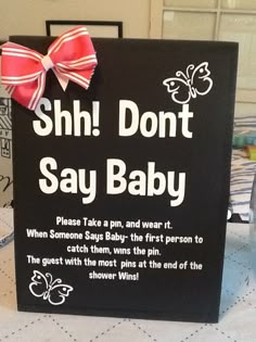 a sign that says shh don't say baby with a bow on it