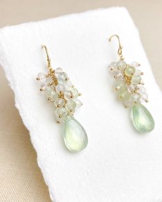 These are a luxe little adornment for your ears! Enjoy the indulgent shimmer of petite prehnite, moonstone, and crystal quartz clusters all crowning ethereal faceted prehnite briolettes. Each hand-picked gem is accented and hand-wrapped in 14k gold-fill. The gold-filled ear wires are smooth and comfortable for effortless wear. What I love the most about these earrings is the soft green and white colors. These can be worn festively for the holidays, but also will carry you through your spring and Elegant Prehnite Gemstone Jewelry, Moonstone Crystal, Moonstone Beads, Quartz Beads, Summer Styles, Earrings In Gold, Quartz Cluster, White Colors, Earrings Drop