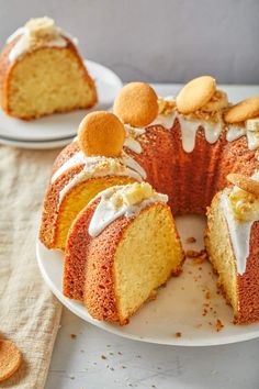 a bundt cake with white icing and oranges on top sits on a plate