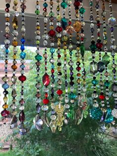 many different colored beads hanging from a window