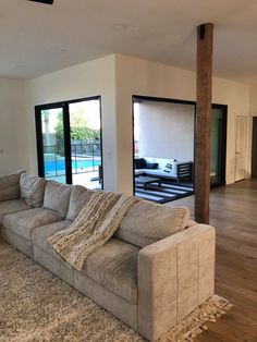 a living room filled with furniture next to a sliding glass door that leads to a pool