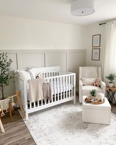 a baby's room with white furniture and decor