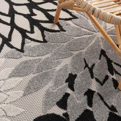 a close up of a chair on a rug with an intricate design in black and white