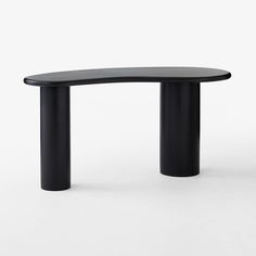 a black curved table sitting on top of a white floor