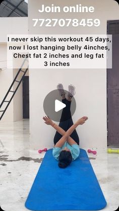 a woman doing yoga on a blue mat in front of a white wall and stairs