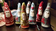 knitted christmas decorations are lined up on a table