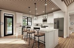 a large kitchen with white cabinets and wooden flooring, along with an island in the middle