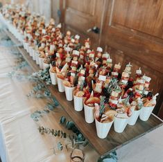 there are many small cups with food in them sitting on the table next to each other