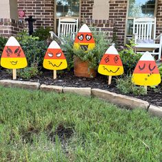 several lawn decorations with faces on them in front of a house