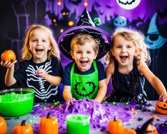 three young children in halloween costumes sitting at a table with pumpkins and decorations on it