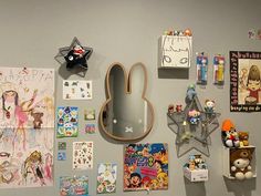 the wall is covered with various children's drawings and magnets, including an animal head