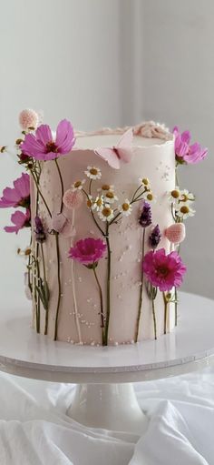 a white cake with pink and purple flowers on it