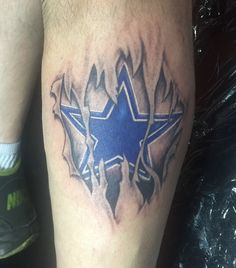 a tattoo on the leg of a man with a blue and black star in it