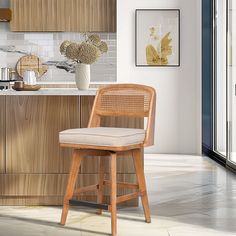 a wooden bar stool sitting in front of a kitchen counter top next to a vase with flowers