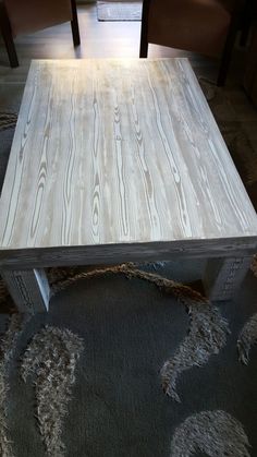 a wooden table sitting on top of a carpeted floor