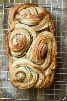 a loaf of bread with swirly toppings on a cooling rack