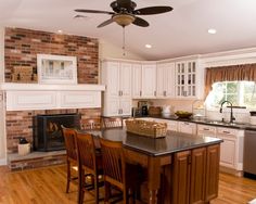 a kitchen with white cabinets and wood floors