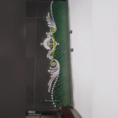 a painting on the side of a building with white and green designs painted on it