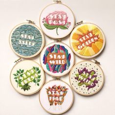 six embroidered hoops with different designs on them, each featuring the word stay wild