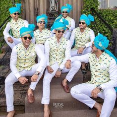 a group of men dressed in white and blue outfits pose for a photo together on steps