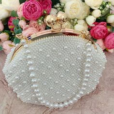 This luxurious encrusted pearl bridal clutch never fails to turn heads with its understated elegance and classic design. Adorned with varying sized White pearls and enhanced with a large creamy pearl clasp, this bridal clutch is the very picture of refinement. This elegant bridal clutch features rose gold trim, attachable chain and large enough for your phone. Complete your list of must-have wedding accessories with the ultimate bridal accessory to finish off your look and storing your wedding d Handheld Evening Bag With Pearl Embroidery For Wedding, Handheld Pearl Embroidered Evening Bag For Weddings, Handheld Pearl Embroidery Evening Bag For Wedding, Pearl White Clutch With Pearl Embroidery For Formal Events, Formal Pearl White Clutch With Pearl Embroidery, Cream Evening Bag With Pearl Embroidery For Wedding, Wedding Embellished Pearl Evening Bag, Formal Bridal Accessories In Pearl White, White Pearl Clutch For Events