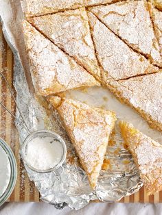 several pieces of pie sitting on top of a glass plate with powdered sugar next to it