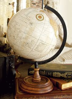 an antique globe sits on top of some books