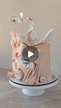 a pink cake with white birds on top and ribbon around the edges, sitting on a table