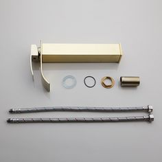 an assortment of metal objects on a white surface, including a handle and two rolls of tape