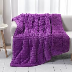 a couch with a purple blanket sitting on top of it