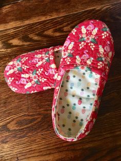 a pair of red slippers sitting on top of a wooden floor