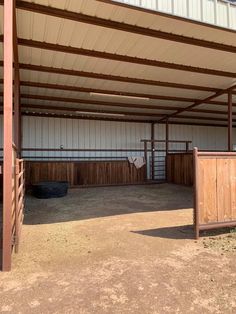 the inside of a horse barn with stalls