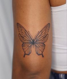 a woman's arm with a butterfly tattoo on the back of her left arm