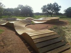 several wooden benches sitting on top of a dirt field