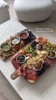 two trays filled with different types of food on top of a table next to a white couch