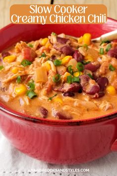 slow cooker creamy chicken chili in a red bowl with a spoon on the side