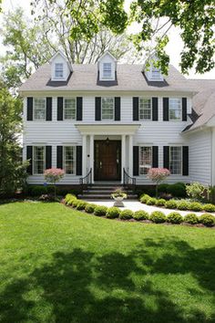 a white house with black shutters on the front