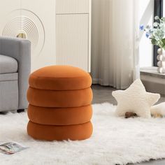 an orange ottoman sitting on top of a white rug