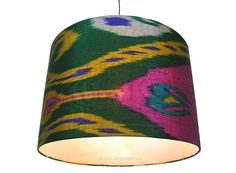 a multicolored lamp shade hanging from a ceiling fixture with a white light bulb