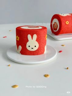 two rolls of red toilet paper with white rabbit faces on them and gold confetti sprinkles