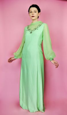 Such a beautiful pastel green 60s maxi gown! The elegant chiffon sleeves and collar give such an ethereal feel to this piece. The beautiful detailed beading o the front is such a nice touch too. The fabric of the body of the garment feels like brushed silk, while the sleeves and collar are a lovely chiffon. Body of dress is lined. Zips up the back with a metal zipper. You can even tie the long chiffon tails behind the back so you hid the zipper seam! Sleeves have snap closures. No garment label Green Floor-length Dress With Sheer Sleeves, Green Ao Dai For Spring Party, Spring Party Green Ao Dai, Vintage Green Evening Maxi Dress, Vintage Green Maxi Dress For Evening, Vintage Green Floor-length Maxi Dress, Vintage Green Maxi Dress For Party, Green Vintage Maxi Dress For Party, Chiffon Sleeves