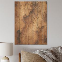 a bed with a wooden wall hanging above it and a lamp on the side table